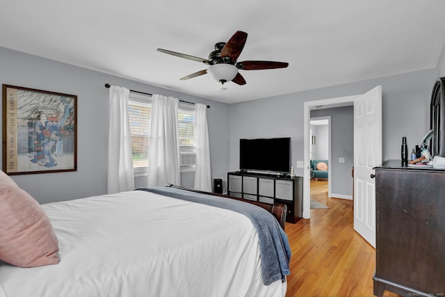 bedroom featuring a ceiling fan, light wood-style flooring, and baseboards