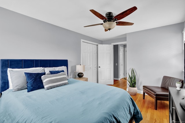 bedroom with light wood finished floors, a closet, ceiling fan, and baseboards