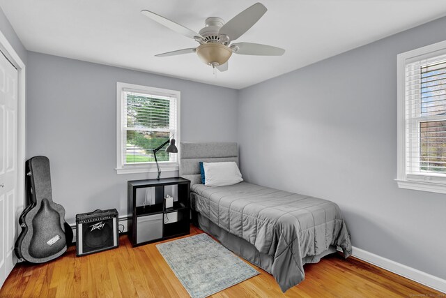 bedroom with baseboards, wood finished floors, and a ceiling fan