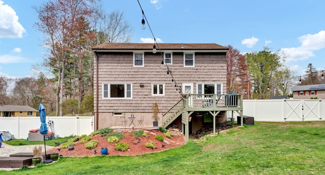 rear view of house featuring a deck, a gate, a lawn, stairway, and a fenced backyard