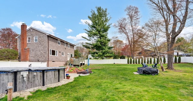 view of yard featuring a fenced backyard, a wooden deck, and a fenced in pool