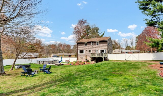 rear view of house featuring a fenced backyard and a yard