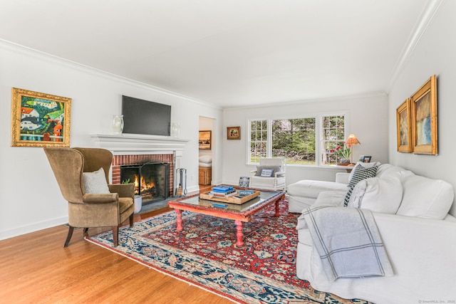 living room featuring baseboards, ornamental molding, a brick fireplace, and wood finished floors
