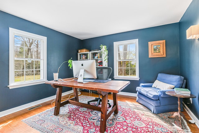 office featuring a wealth of natural light, wood finished floors, and visible vents