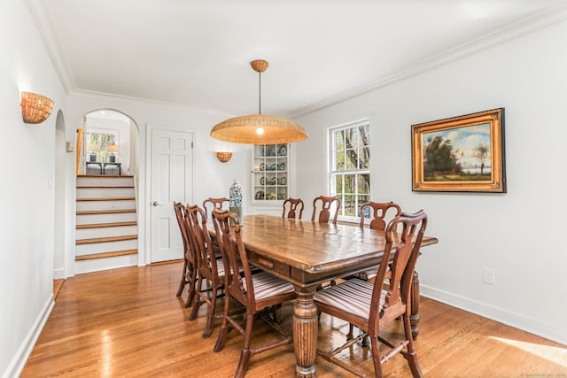 dining area with baseboards, ornamental molding, stairs, and light wood-style flooring