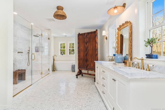 full bathroom featuring a freestanding bath, double vanity, visible vents, a marble finish shower, and a sink