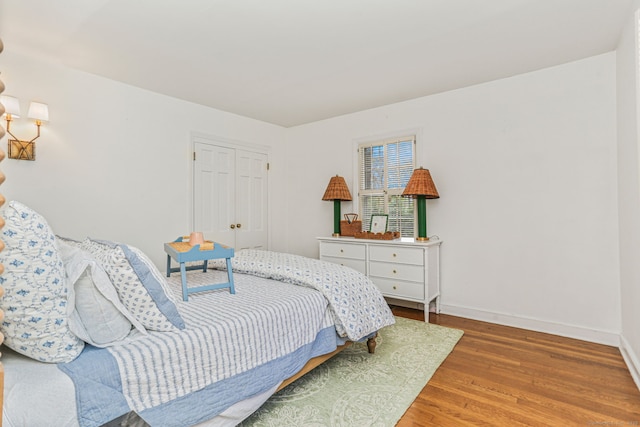 bedroom with baseboards, a closet, and light wood-type flooring