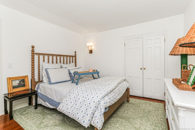 bedroom featuring dark wood-type flooring, a closet, and baseboards