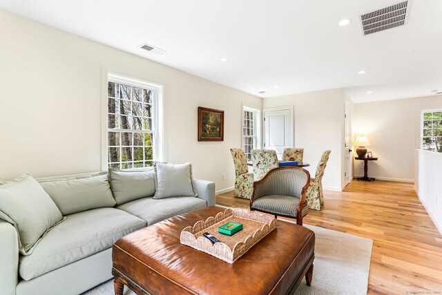 living area with recessed lighting, visible vents, and light wood-type flooring