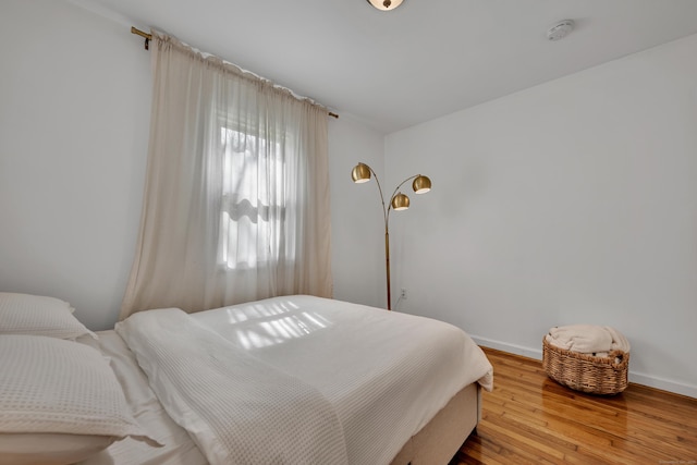 bedroom with baseboards and wood finished floors