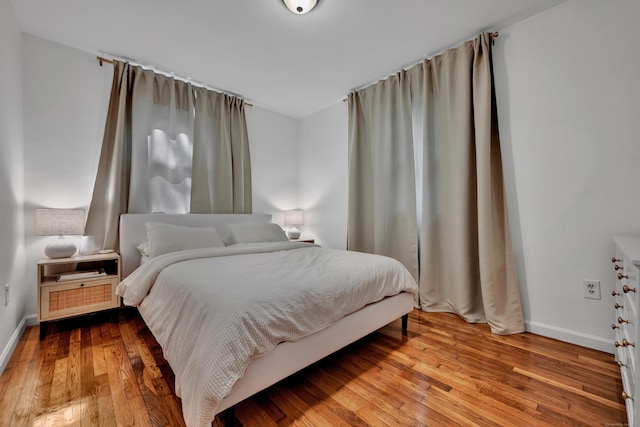 bedroom featuring baseboards and hardwood / wood-style flooring
