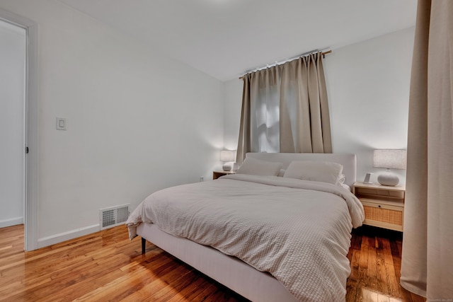 bedroom featuring light wood-style floors, baseboards, and visible vents