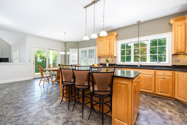 176 Fox Hollow Ln, Bristol, CT 06010 - kitchen with a sink, a center island, decorative backsplash, a kitchen bar, and baseboards