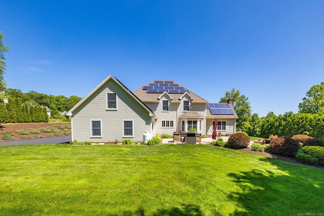 176 Fox Hollow Ln, Bristol, CT 06010 - traditional home featuring roof mounted solar panels, a patio area, a front yard, and a chimney
