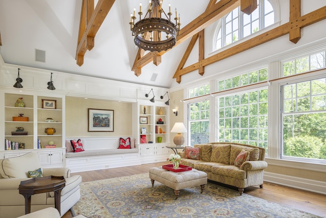 living area with high vaulted ceiling, wood finished floors, beam ceiling, and built in shelves