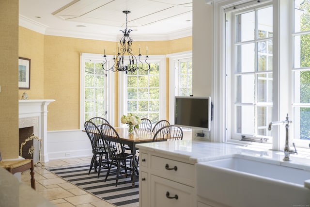 kitchen featuring a sink, a chandelier, white cabinets, healthy amount of natural light, and crown molding