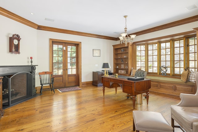 home office featuring light wood-style floors, a chandelier, crown molding, a fireplace, and baseboards