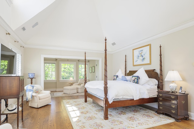 bedroom featuring wood finished floors, ornamental molding, baseboards, and high vaulted ceiling