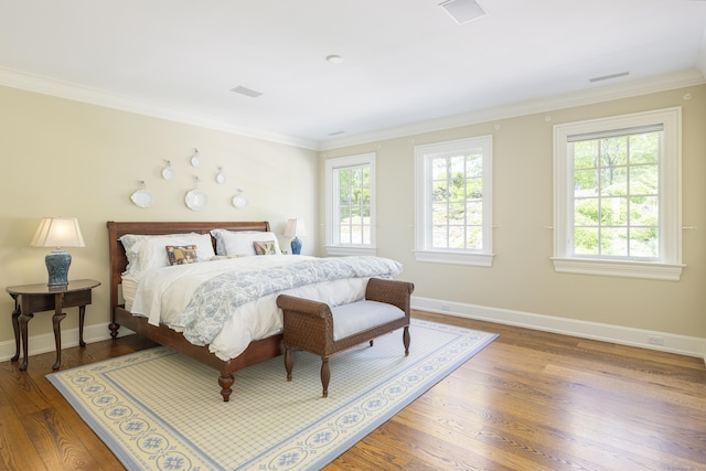 bedroom featuring ornamental molding, wood finished floors, and baseboards