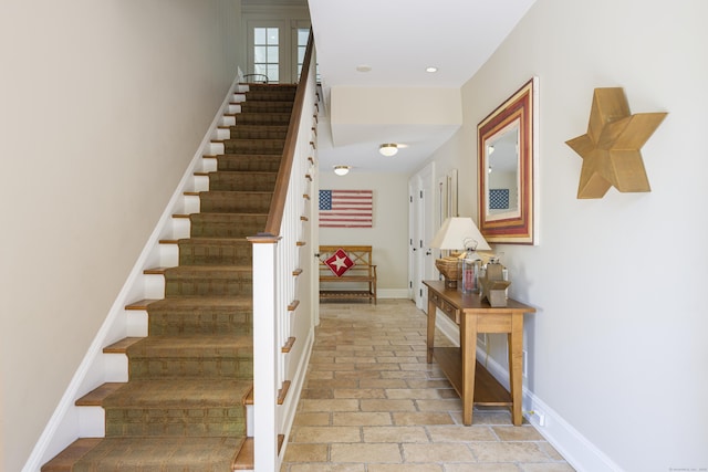 staircase featuring brick flooring and baseboards