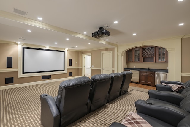 cinema room with bar with sink, crown molding, and recessed lighting