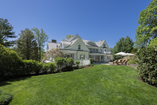 back of property with french doors, a yard, a chimney, and a patio