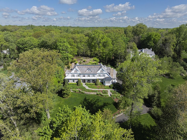 aerial view of property and surrounding area featuring a heavily wooded area