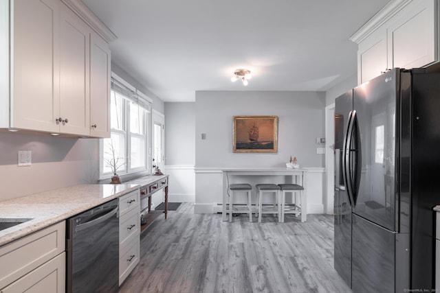 kitchen featuring dishwasher, black refrigerator with ice dispenser, white cabinets, and light wood-type flooring