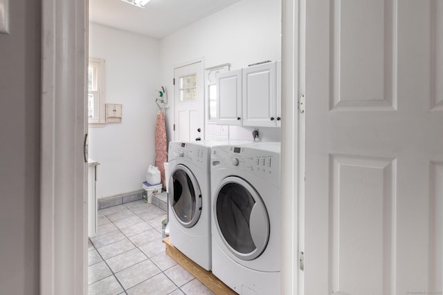 laundry area with cabinet space, washing machine and clothes dryer, and light tile patterned floors