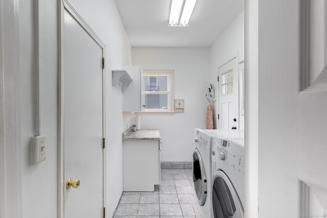 laundry room with baseboards, washing machine and clothes dryer, cabinet space, and light tile patterned floors