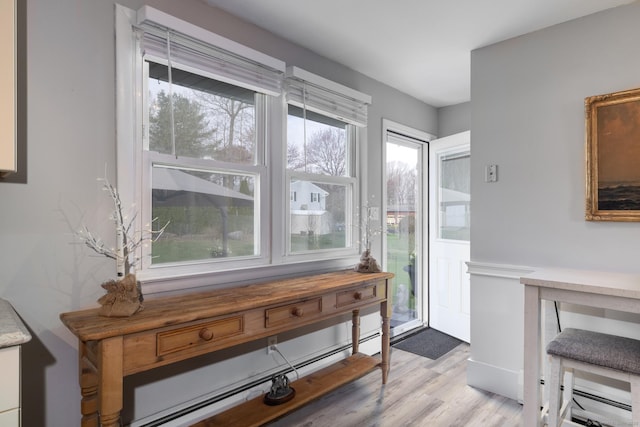doorway to outside with a baseboard heating unit and light wood-type flooring