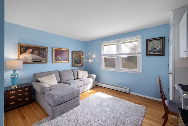 living area with a baseboard radiator, baseboards, and wood finished floors