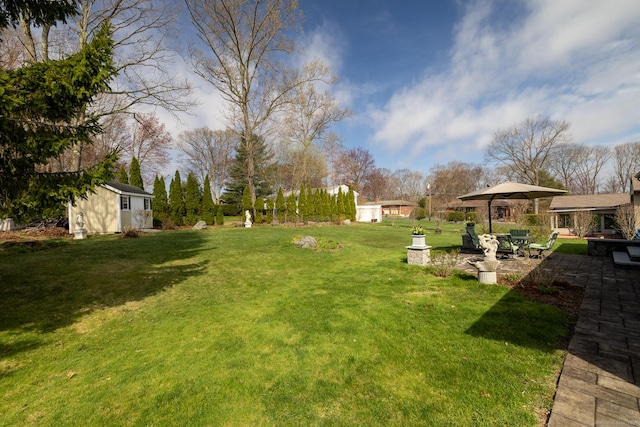 view of yard featuring a patio and an outbuilding