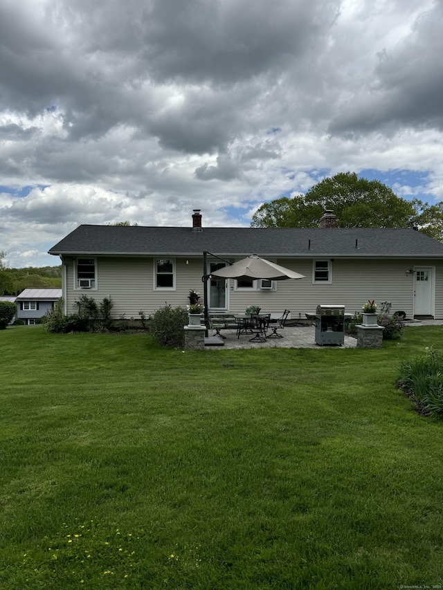 211 Crest St, Waterbury, CT 06708 - rear view of property with entry steps, a patio area, a lawn, and a chimney