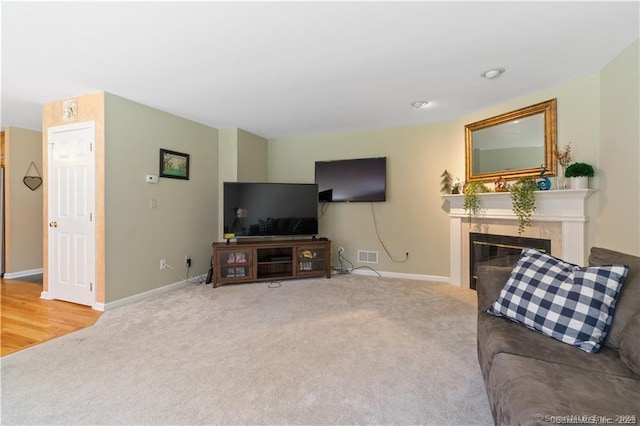 carpeted living room with visible vents, baseboards, and a tile fireplace