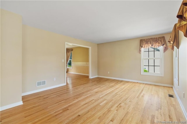 spare room with visible vents, a healthy amount of sunlight, and light wood-type flooring