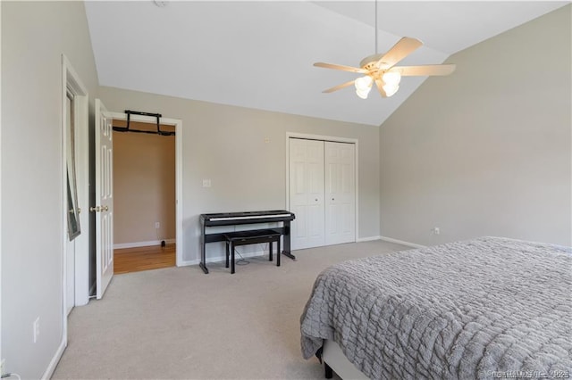 carpeted bedroom featuring a ceiling fan, baseboards, lofted ceiling, and a closet