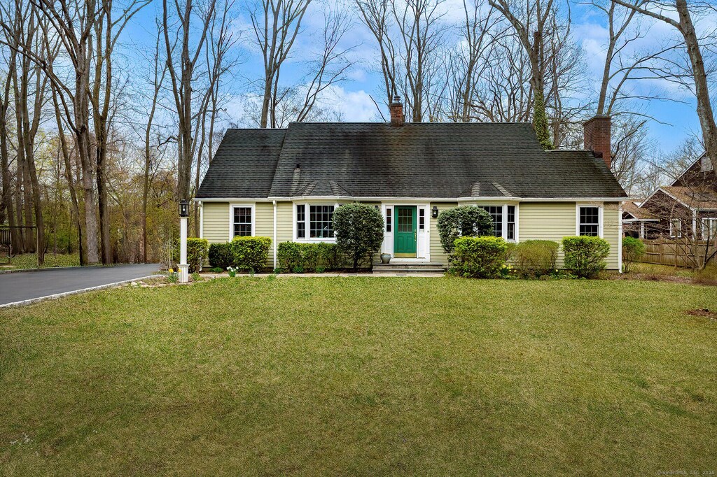 33 Riverview Dr, Norwalk, CT 06850 - new england style home with a chimney, fence, a front lawn, and driveway