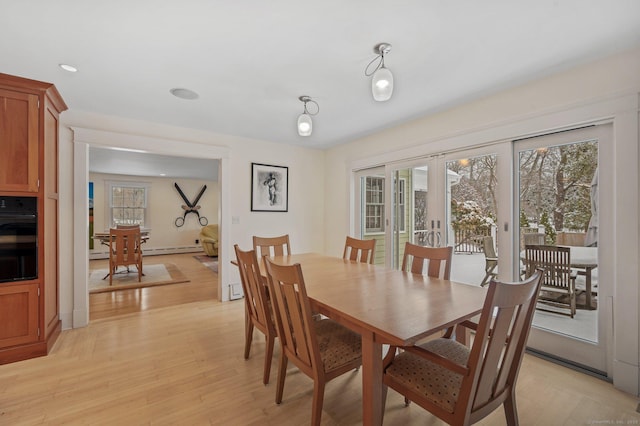 dining area featuring light wood-type flooring, a wealth of natural light, baseboard heating, and french doors