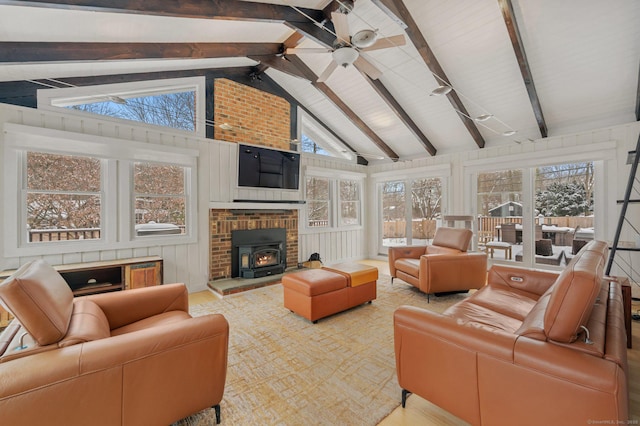 living area featuring a ceiling fan, a wood stove, and vaulted ceiling with beams