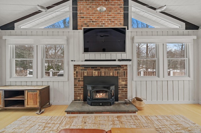 living area featuring lofted ceiling with beams, a wealth of natural light, and wood finished floors