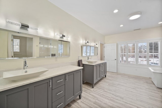 full bath with two vanities, plenty of natural light, and a sink