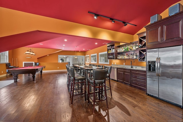 kitchen featuring dark wood-style floors, open shelves, vaulted ceiling, rail lighting, and appliances with stainless steel finishes