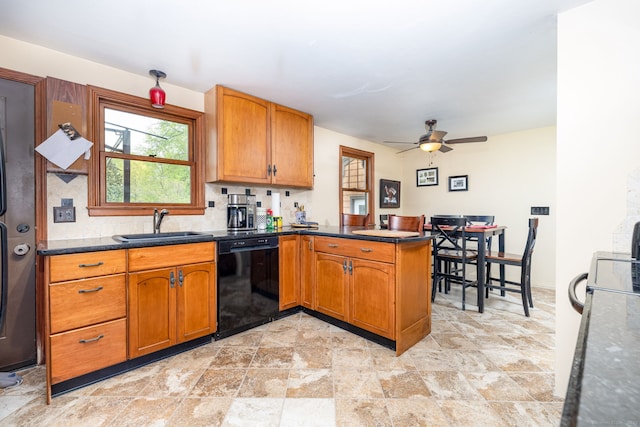 kitchen featuring a peninsula, a sink, black dishwasher, brown cabinetry, and stone finish floor