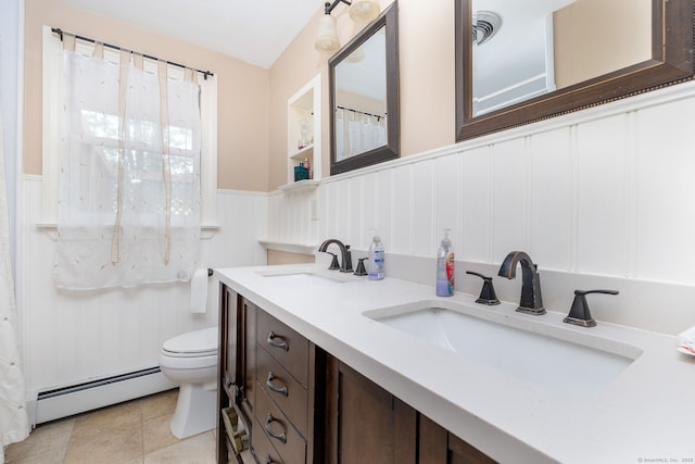 bathroom featuring toilet, a baseboard radiator, a wainscoted wall, and a sink