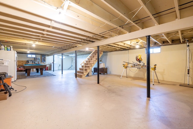 basement featuring stairway, freestanding refrigerator, pool table, and washer / clothes dryer