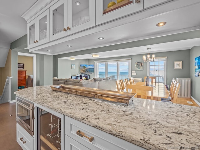 50 Grove Way, Clinton, CT 06413 - kitchen featuring a chandelier, glass insert cabinets, light stone countertops, and baseboards