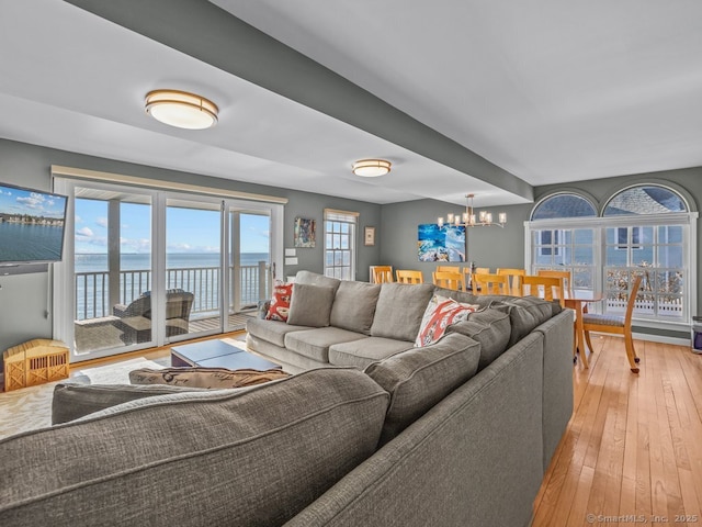 50 Grove Way, Clinton, CT 06413 - living room featuring light wood-style flooring, a water view, and a notable chandelier