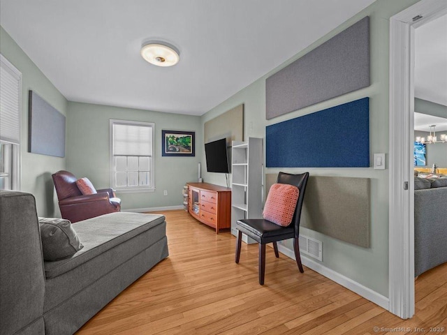 50 Grove Way, Clinton, CT 06413 - living area with wood finished floors, baseboards, and an inviting chandelier