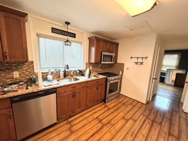 136 Oberlin Rd, Hamden, CT 06514 - kitchen featuring brown cabinets, stainless steel appliances, backsplash, wood finished floors, and a sink